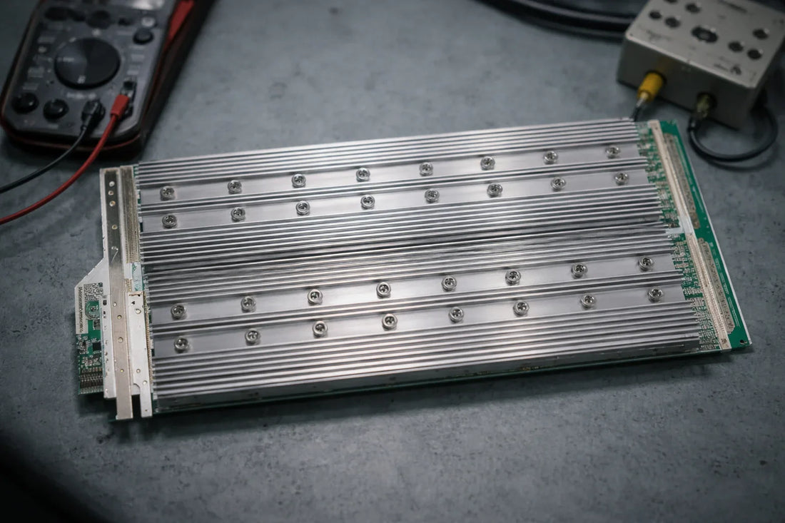 Whatsminer M30S hashboard on a repair bench with screw-mounted heatsinks and diagnostic tools