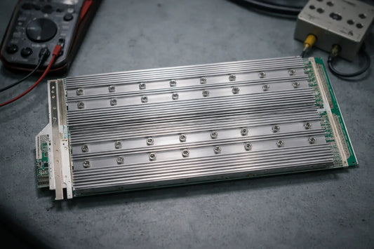 Whatsminer M30S hashboard on a repair bench with screw-mounted heatsinks and diagnostic tools