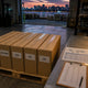 Editorial photograph of a Shenzhen warehouse loading bay with parts cartons labelled for Latam, SE Asia, CIS, EU and US destinations.