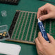 Technician applying thermal paste to ASIC hashboard with stencil tool — re-paste guide