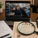 Procurement desk with video call to Chinese workshop visible on laptop, due-diligence checklist and business registration document — verifying a Chinese mining parts supplier guide