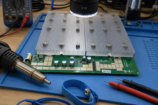 Antminer S19j Pro hashboard on repair workbench with BM1362 ASIC chips and rework tools — repair guide