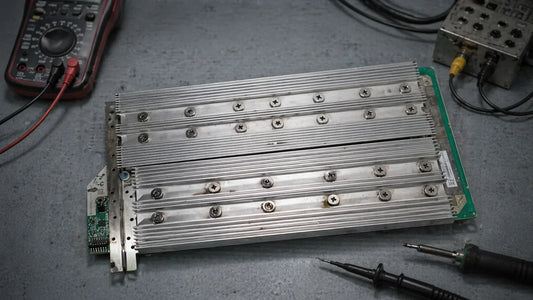 Whatsminer M50 hashboard with KF1968 chips next to an M53 hydro cold plate on a repair bench